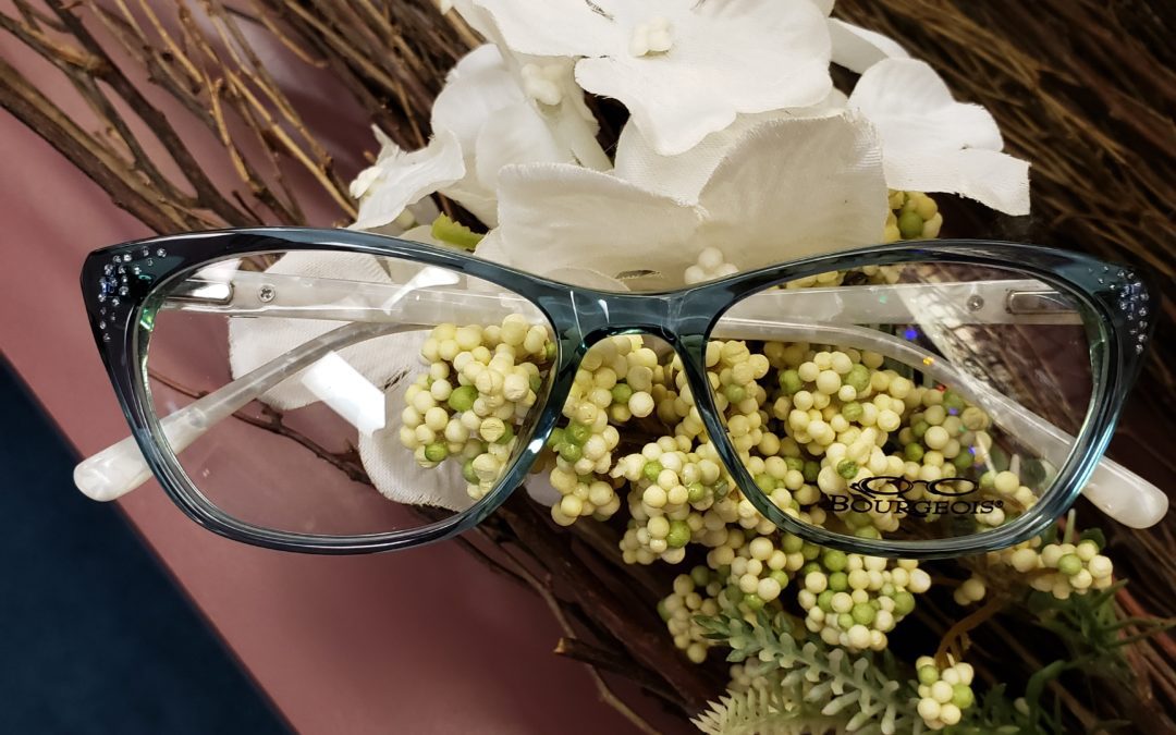 A pair of glasses on top of some bouquets